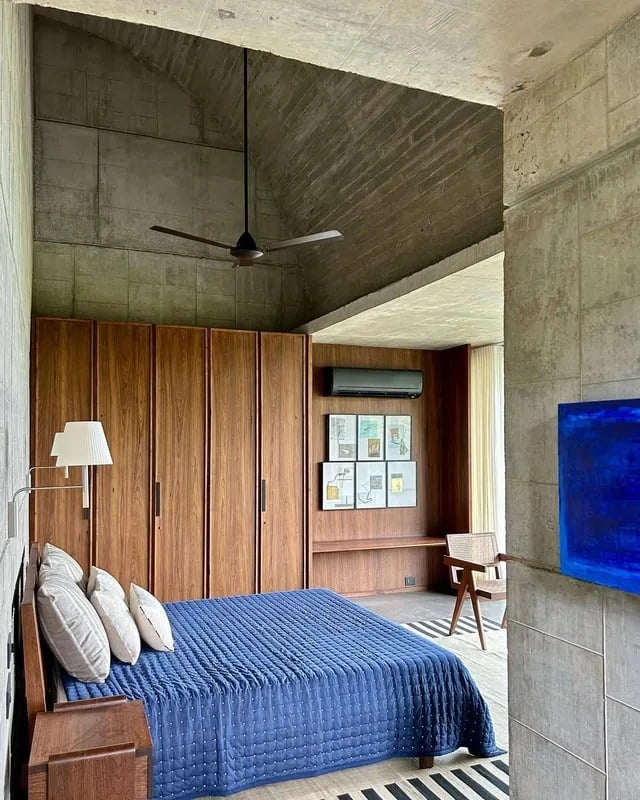 Bedroom with indigo bedding and concrete walls